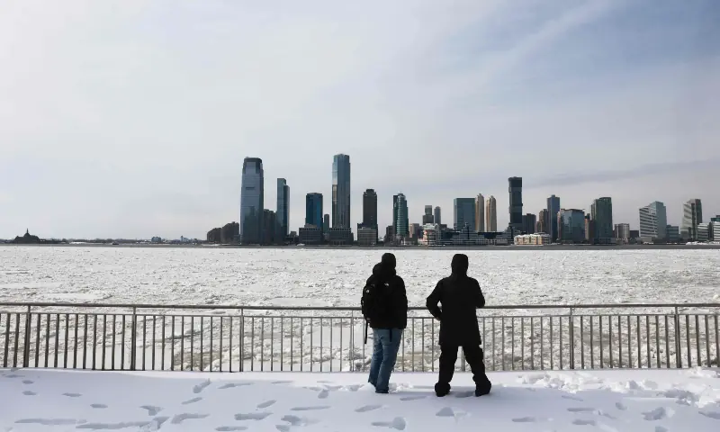 People stand near ice floats covering part of the Hudson River along the Manhattan shoreline as New York City experiences frigid temperatures following a winter storm over the weekend, in New York City on January 27, 2026. &mdash; AFP
