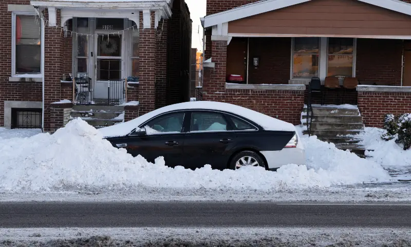 A car remains partially buried by plowed snow along a residential street in the aftermath of a winter storm in the St. Louis area, Missouri, US on January 26, 2026. &mdash; Reuters