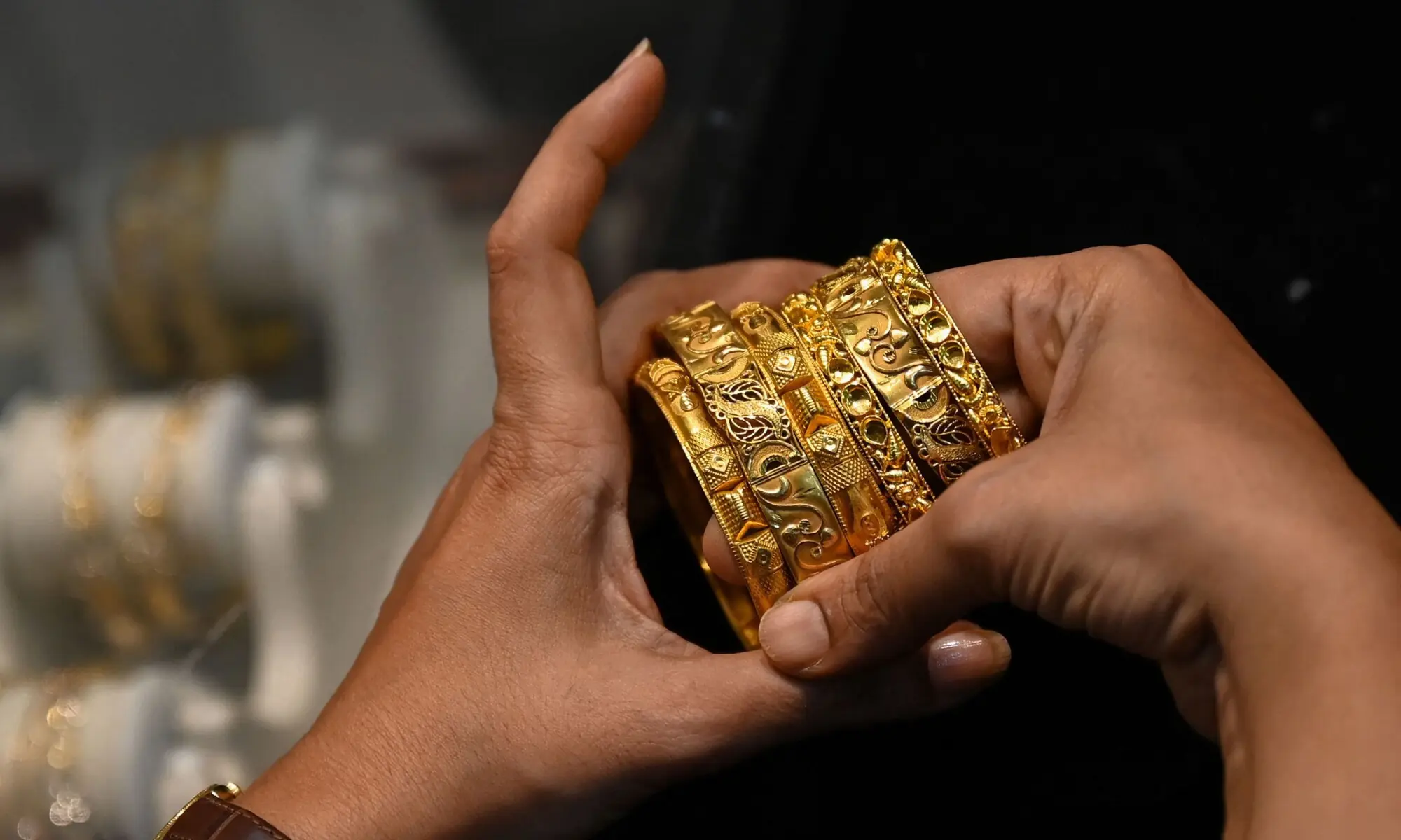 Picture taken on August 11 2021 shows a customer handling gold bracelets at a jewellery shop in Mumbai. &mdash; AFP