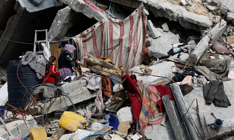 Palestinians walk amid the rubble of residential buildings destroyed during the war, in Gaza City, January 28. &mdash; Reuters