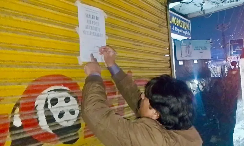 A Food Authority officials seals a frozen food shop in accordance with the direction of AJK Supreme Court in Tahli Mandi area of Muzaffarabad. — photo by author A Food Authority officials seals a frozen food shop in accordance with the direction of AJK Supreme Court in Tahli Mandi area of Muzaffarabad. — photo by author
