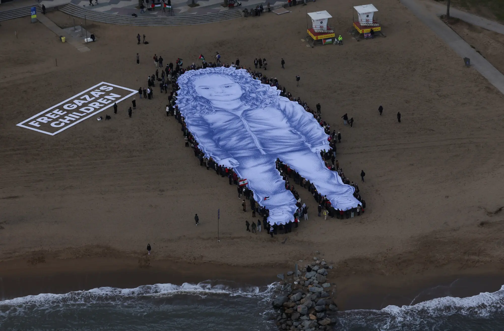 Protesters in Barcelona unfurl giant portrait of Hind Rajab to mark her second death anniversary