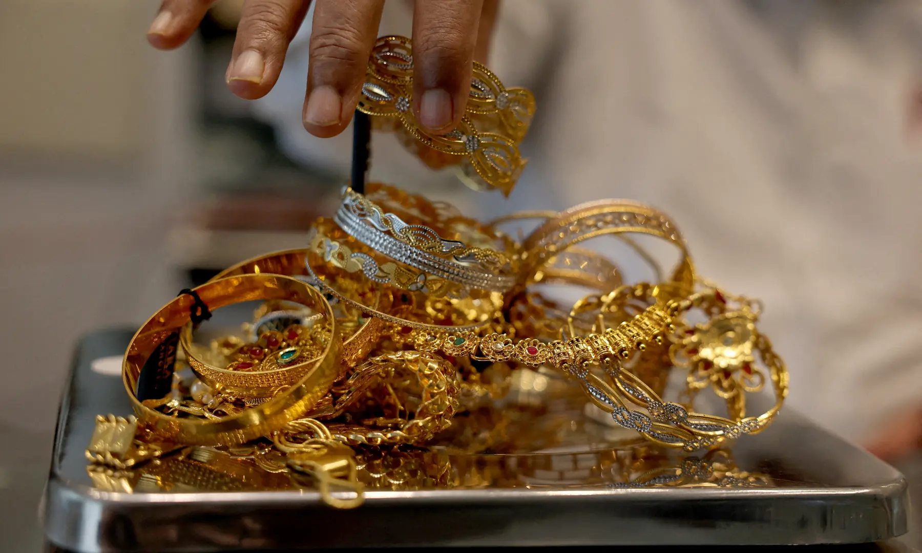 A goldsmith weighs gold jewellery inside a showroom in Ahmedabad, India, July 31, 2025 &mdash; REUTERS/File
