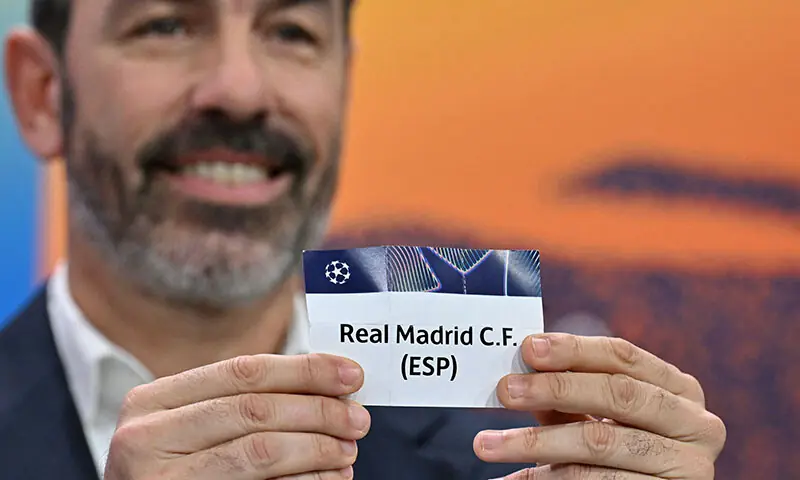 Former French football player and UEFA Champions League ambassador Robert Pires holds up the slip of Real Madrid during the 2025-2026 UEFA Champions League knockout phase play-off draw at the House of European Football in Nyon, Switzerland on January 30. — AFP