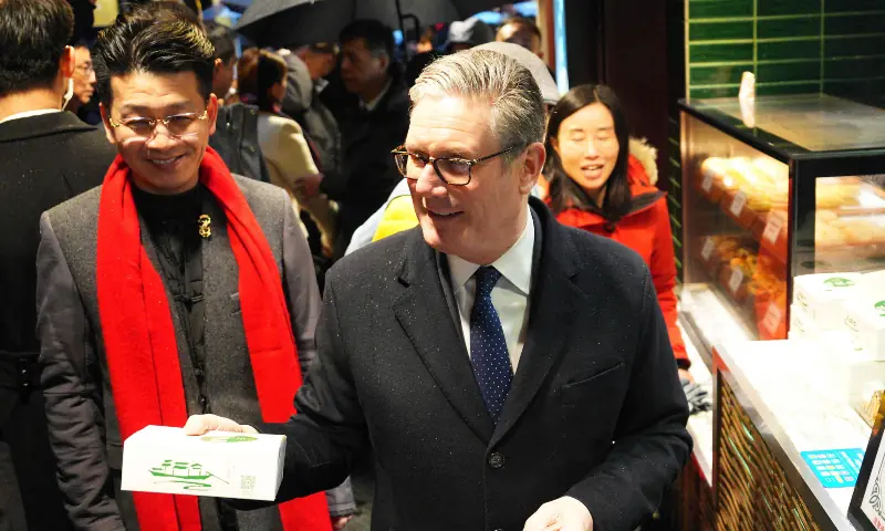 Britain&rsquo;s Prime Minister Keir Starmer buys a box of biscuits on a visit to Yuyuan Garden in Shanghai. &mdash; AFP