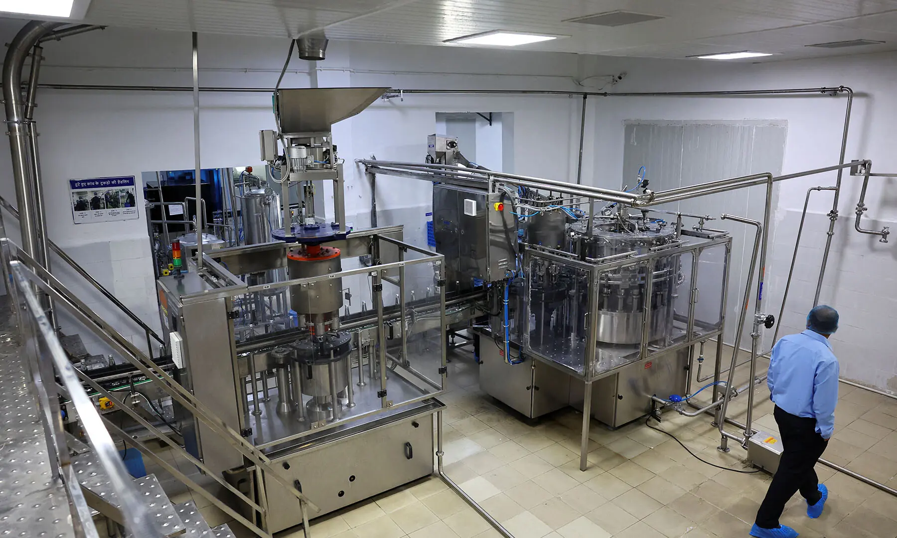 A worker walks as natural water is filled into glass bottles at a water filling machine at Tata&rsquo;s Himalayan natural mineral water bottling plant in Dhaula Kuan, Himachal Pradesh, India on October 16, 2025. &mdash; Reuters