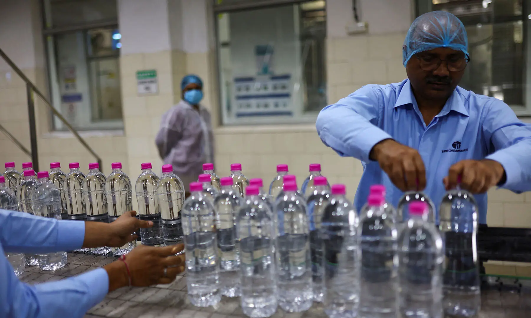 Workers arrange PET (Polyethylene Terephthalate) bottles filled with natural water on a conveyor at Tata&rsquo;s Himalayan natural mineral water bottling plant in Dhaula Kuan, Himachal Pradesh, India on October 16, 2025. &mdash; Reuters/File