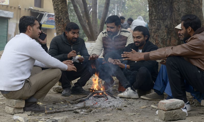 Youngster huddle around a fire in F-6 in Islamabad on Thursday. &mdash; White Star