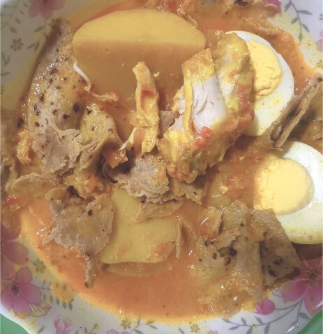 The full painda plate (or bowl), including chapati pieces soaked in curry with chicken pieces, potato and boiled egg