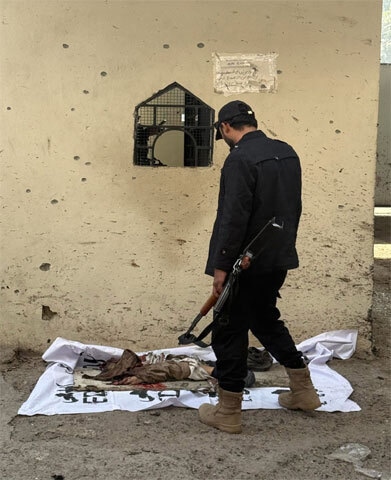 A security personnel member stands near the remains of a suicide bomber after an attack on the Frontier Corps headquarters on November 24, 2025