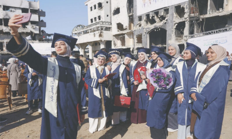 university students take a selfie during their graduation ceremony in the courtyard of Al-Shifa hospital in Gaza City.&mdash;AFP