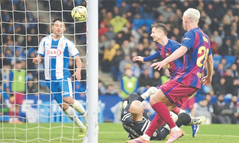 BARCELONA: Barcelona’s Robert Lewandowski (second R) scores during the La Liga match against Espanyol at RCDE Stadium.—AFP BARCELONA: Barcelona’s Robert Lewandowski (second R) scores during the La Liga match against Espanyol at RCDE Stadium.—AFP