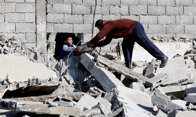 Palestinians retrieve their belongings from a collapsed house that was damaged in an Israeli strike, in the central Gaza Strip. — Reuters Palestinians retrieve their belongings from a collapsed house that was damaged in an Israeli strike, in the central Gaza Strip. — Reuters