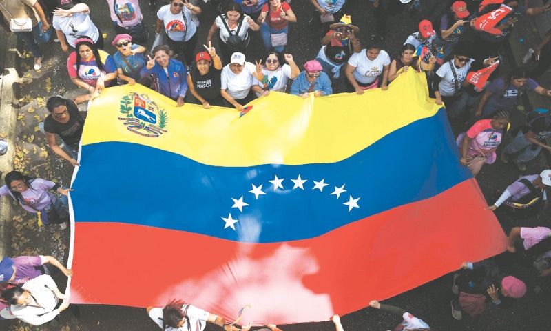 CARACAS: People wave a massive Venezuelan flag during a rally in support of ousted Venezuelan president Nicolas Maduro and his wife Cilia Flores.&mdash;AFP                                    Report on Page 12