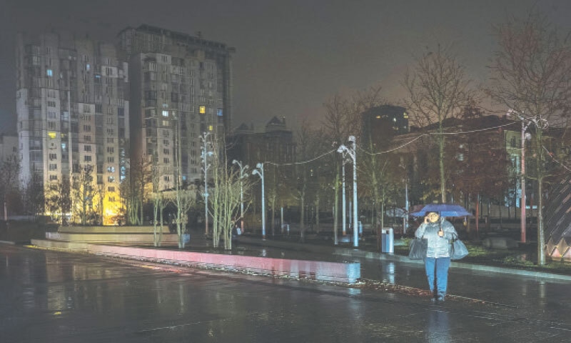 A resident crosses a street during a power blackout in Ukraine after civil infrastructure was hit by Russian missile and drone attacks.&mdash;Reuters
