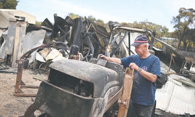 A man inspects damage to his property amid bushfires in Harcourt, Victoria. &mdash; Reuters