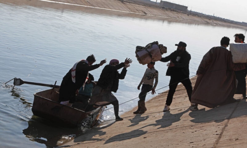 Syrians use a boat to flee a Kurdish-controlled area in Rasm al Harmal, east of Aleppo, before a deadline set by the army to evacuate the region.&mdash;AFP