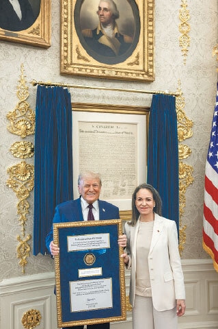 PRESIDENT Donald Trump holds the Nobel Peace Prize of Venezuelan leader Maria Corina Machado, during their meeting in the Oval Office. According to the White House, Trump intends to keep the prize.—Reuters