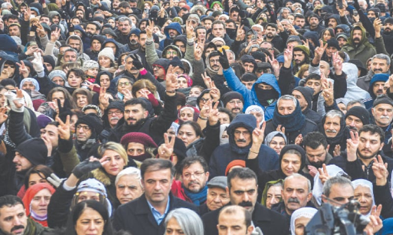 Diyarbakir (Turkiye): Protesters gather and flash victory signs during a demonstration against the attacks by the Syrian government forces on Monday. Despite heavy snow, protesters rallied in the main city in the Kurdish-majority southeast, where clashes erupted as police tried to stop them from marching.&mdash;AFP