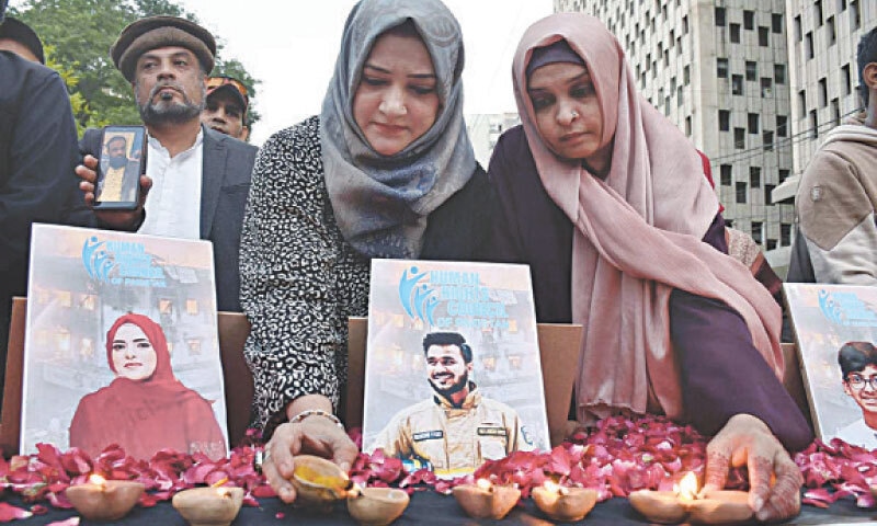 People light earthen lamps outside the Karachi Press Club on Wednesday in remembrance of the victims of the Gul Plaza fire tragedy.—APP People light earthen lamps outside the Karachi Press Club on Wednesday in remembrance of the victims of the Gul Plaza fire tragedy.—APP