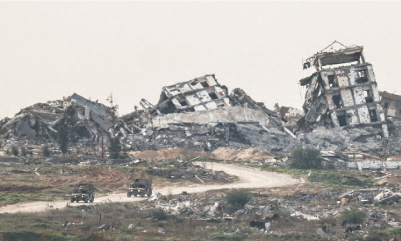 ISRAELI military vehicles drive past destroyed buildings in the Gaza Strip after Wednesday&rsquo;s latest strikes.&mdash;Reuters