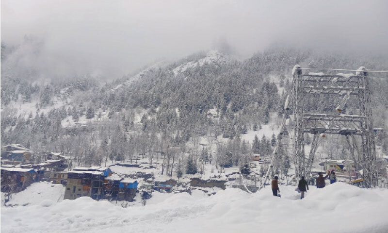 A snow-blanketed view of Sharda town in Neelum Valley, about 137 kilometres from the Azad Jammu and Kashmir (AJK) capital, Muzaffarabad, following heavy snowfall on Friday. A tourist pauses to take a selfie while locals are seen fixing an AJK flag on a bridge linking neighbourhoods on opposite banks of the ice-laden Neelum River. — Text and Photo by Tariq Naqash A snow-blanketed view of Sharda town in Neelum Valley, about 137 kilometres from the Azad Jammu and Kashmir (AJK) capital, Muzaffarabad, following heavy snowfall on Friday. A tourist pauses to take a selfie while locals are seen fixing an AJK flag on a bridge linking neighbourhoods on opposite banks of the ice-laden Neelum River. — Text and Photo by Tariq Naqash