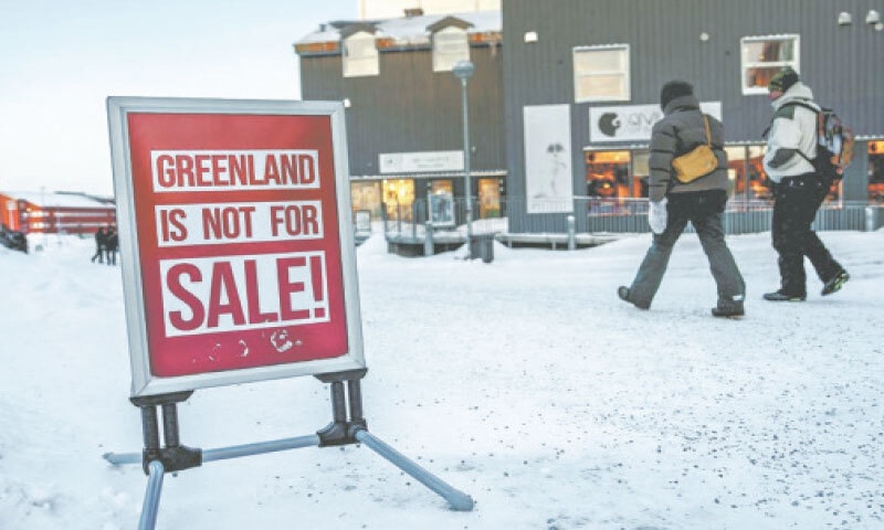 People walk past a street sign in Nuuk, Greenland, protesting a US threat to take over the Danish territory.&mdash;Courtesy China Daily