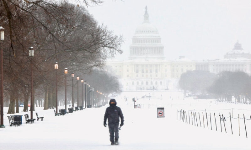 A MAN walks along the National Mall as snow falls in Washington.&mdash;AFP