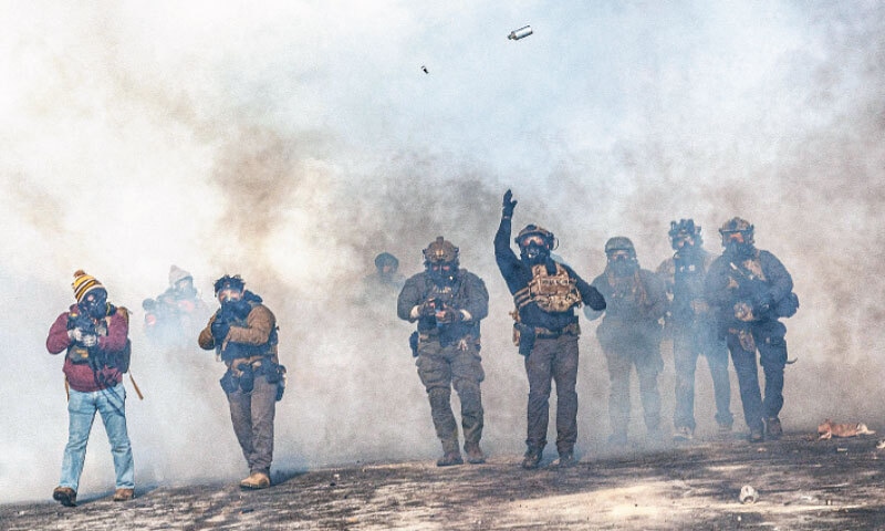 A FEDERAL agent lobs a tear gas canister towards protesters during the clashes following the second fatal shooting in Minneapolis.&mdash;AFP