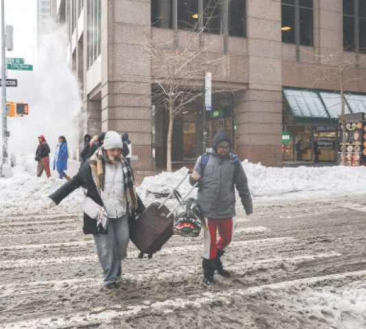 Pedestrians walk on a snow-covered street in New York City.&mdash;Reuters