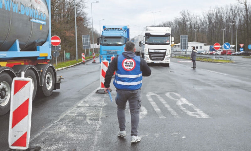 A Serbian driver walks between trucks at a border crossing between Serbia and Croatia. The truck drivers are demanding changes to the European Union visa system that restricts their time in the EU.&mdash;AFP