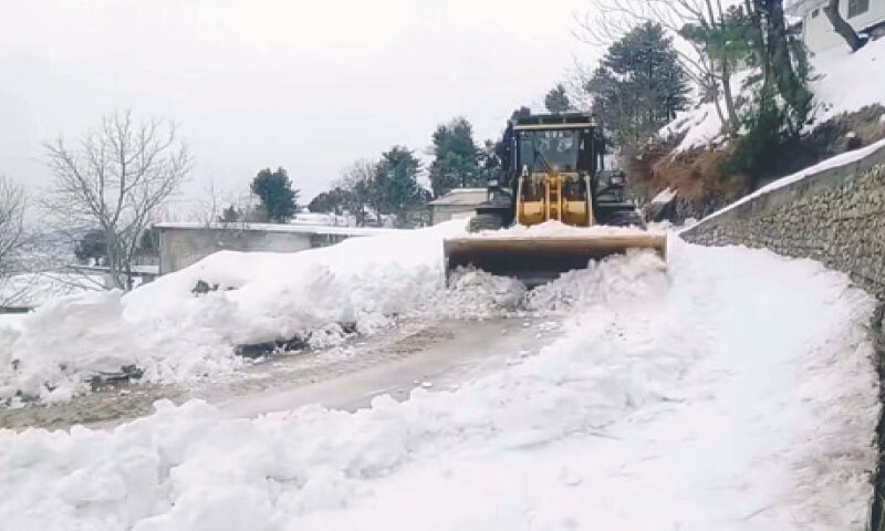 ABBOTTABAD: A municipal worker uses a snow plough to clear the road after heavy snowfall.&mdash;PPI