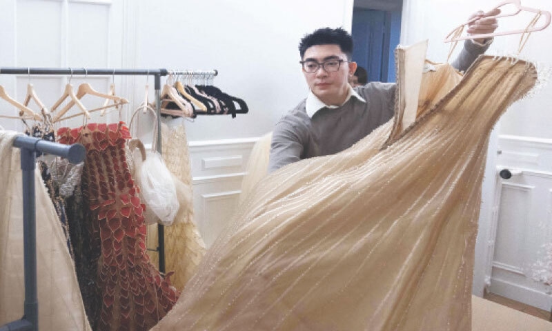 Phan Huy from Vietnam, the youngest-ever fashion designer, grabs an item of his collection during a show in the French capital.&mdash;AFP