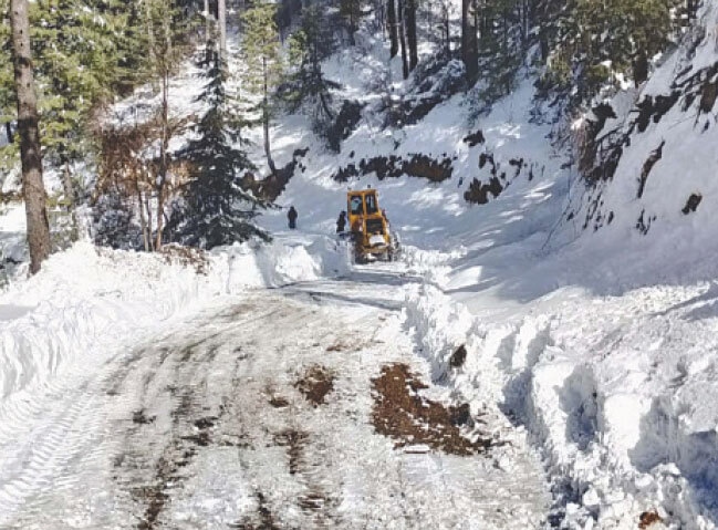  ABBOTTABAD: Heavy machinery is used to clear a road after intense snowfall in the Galiyat.&mdash;PPI 