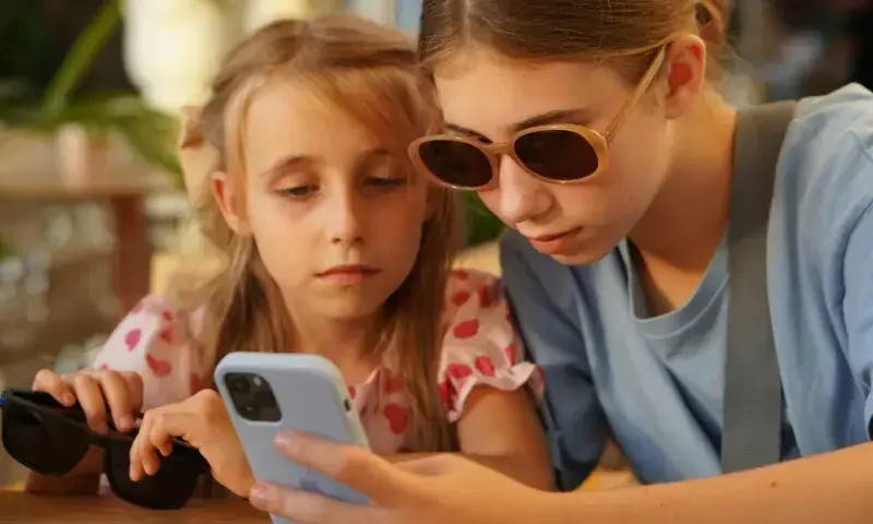Two kids looking at a phone in Moscow, Russia, on September 5, 2024. &mdash; Tati Odintsova/ Unsplash