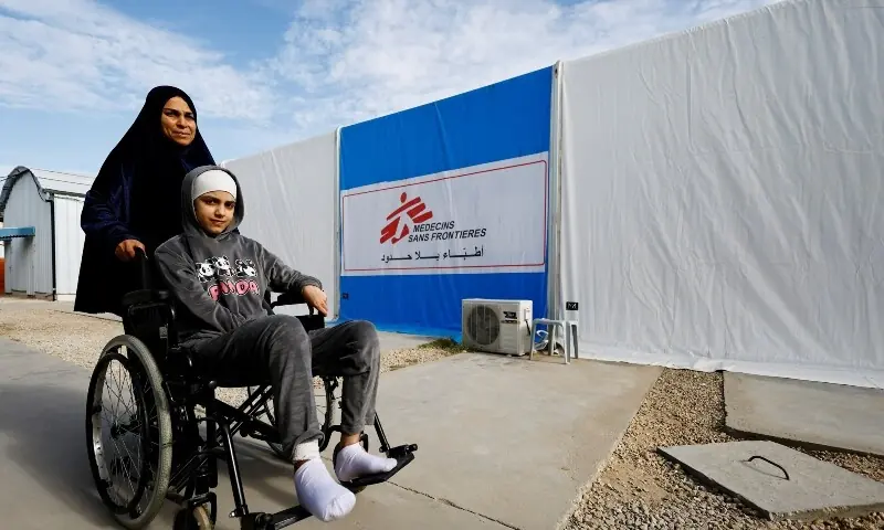 A Palestinian woman helps a burn victim, Maria Abu Aawad, at a Doctors Without Borders (MSF) hospital, in Zawaida, in the central Gaza Strip, January 26. &mdash; Reuters