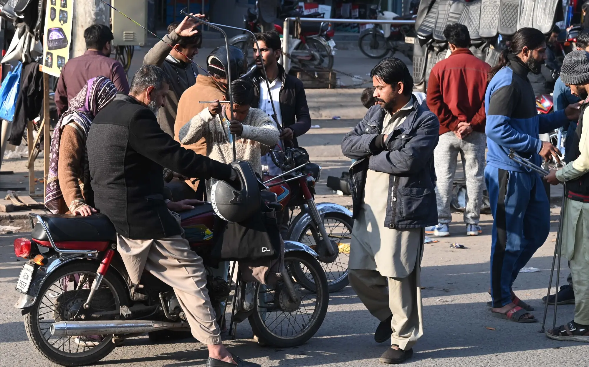 Vendors installing safety rods on a motorcycle. Photo: Arif Ali/White Star