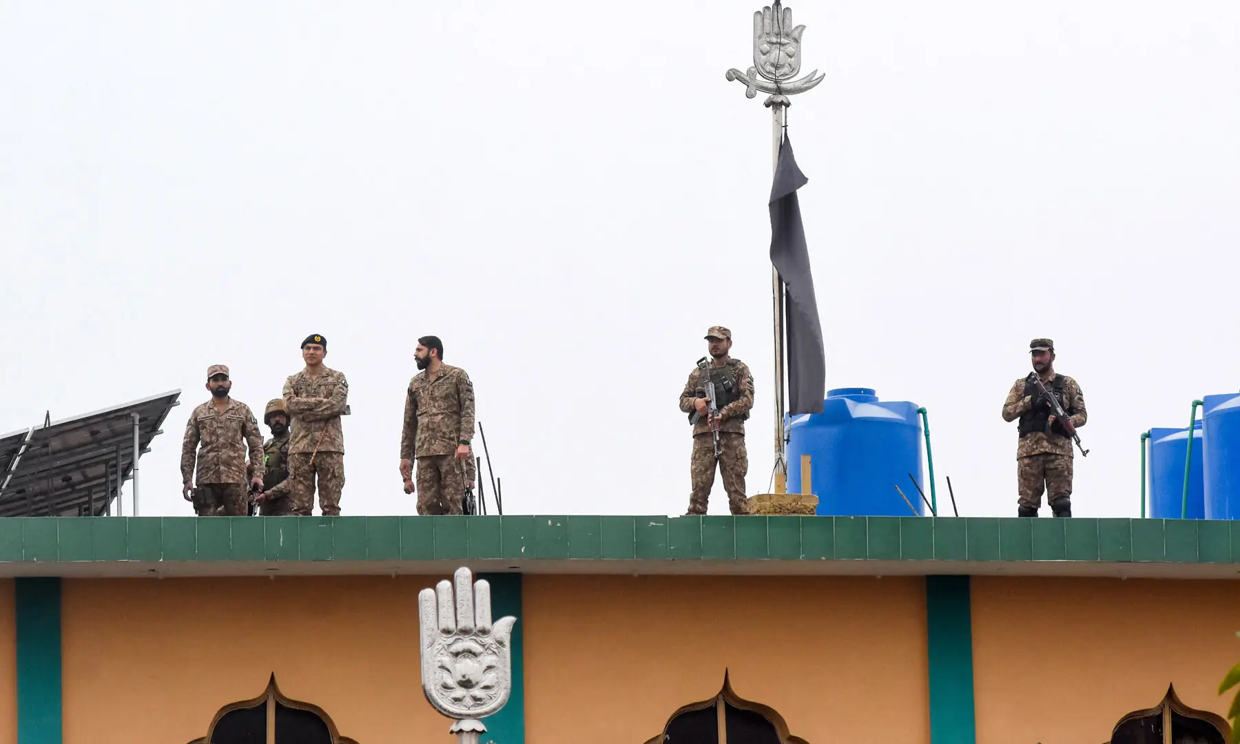 Security personnel stand guard on the roof after a deadly explosion at an imambargah in Islamabad, Pakistan, February 6, 2026. &mdash; Reuters