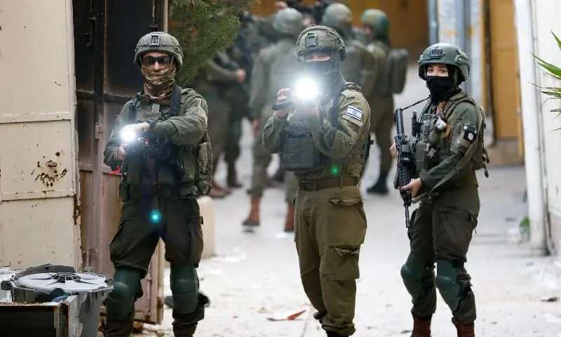 Israeli soldiers point their weapons at the camera, during a weekly settlers&rsquo; tour in Hebron, in the Israeli-occupied West Bank, February 7. &mdash; Reuters