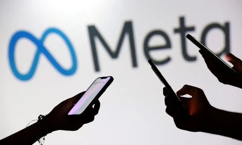Teenagers pose for a photo while holding smartphones in front of a Meta logo in this illustration taken September 11, 2025. &mdash;Reuters/File