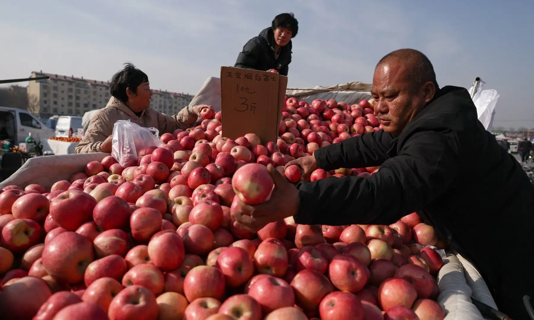 Costumers buy apples at an outdoor market ahead of the Lunar New Year, in Beijing, China February 10, 2026. &mdash;Reuters