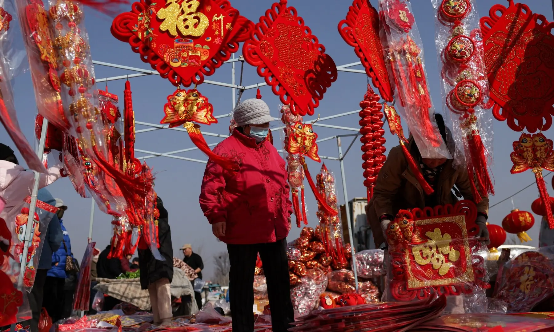 A vendor selling Spring Festival ornaments attends to a customer at an outdoor market ahead of the Lunar New Year, in Beijing, China February 10, 2026. &mdash;Reuters
