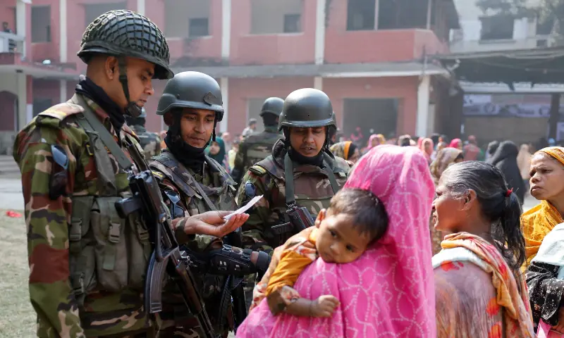 Army personnel assist voters at a polling station during the 13th general election in Dhaka, Bangladesh on February 12. &mdash; Reuters