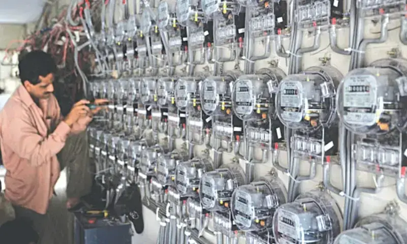 In this file photo, a man is seen inspecting meters.—AFP/file In this file photo, a man is seen inspecting meters.—AFP/file
