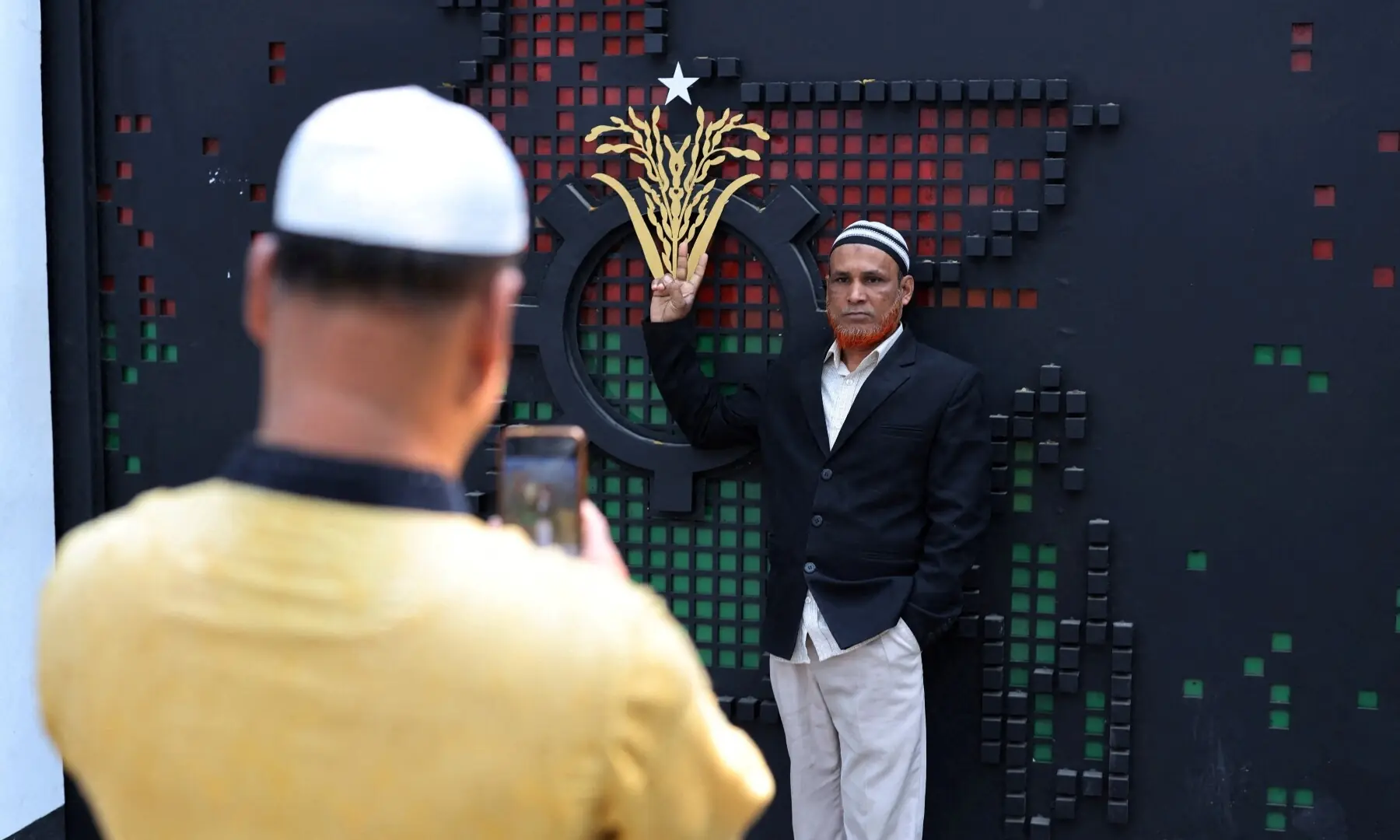 A Bangladesh Nationalist Party (BNP) supporter shows the victory sign while posing for a photo next to BNP&acirc;&euro;&trade;s voting symbol ollowing the 13th general election, in Dhaka, Bangladesh, February 13, 2026. &mdash;Reuters