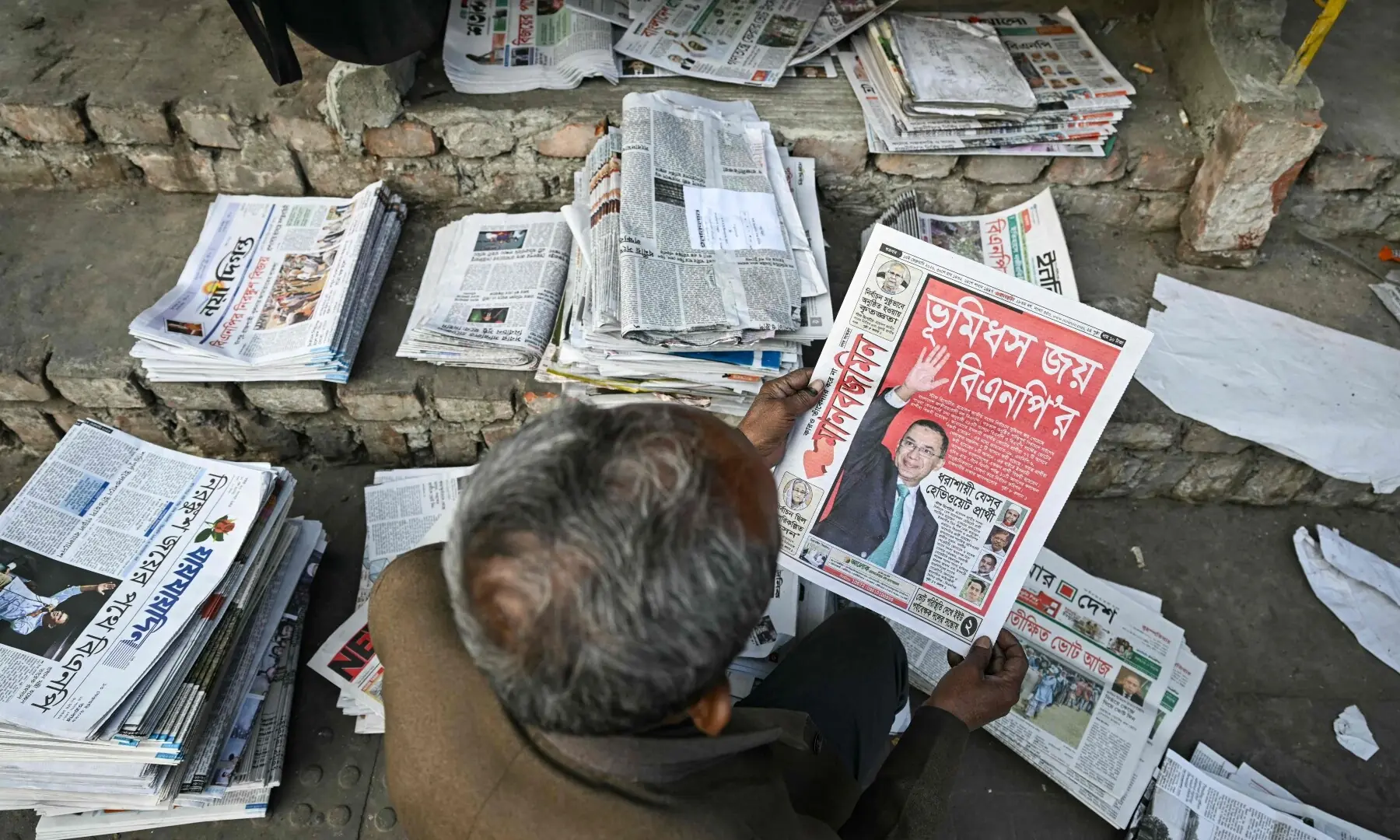 A man holds a newspaper with a front page featuring Bangladesh Nationalist Party (BNP) chairman and election candidate Tarique Rahman, on a street in Dhaka on February 13, 2026. &mdash;AFP