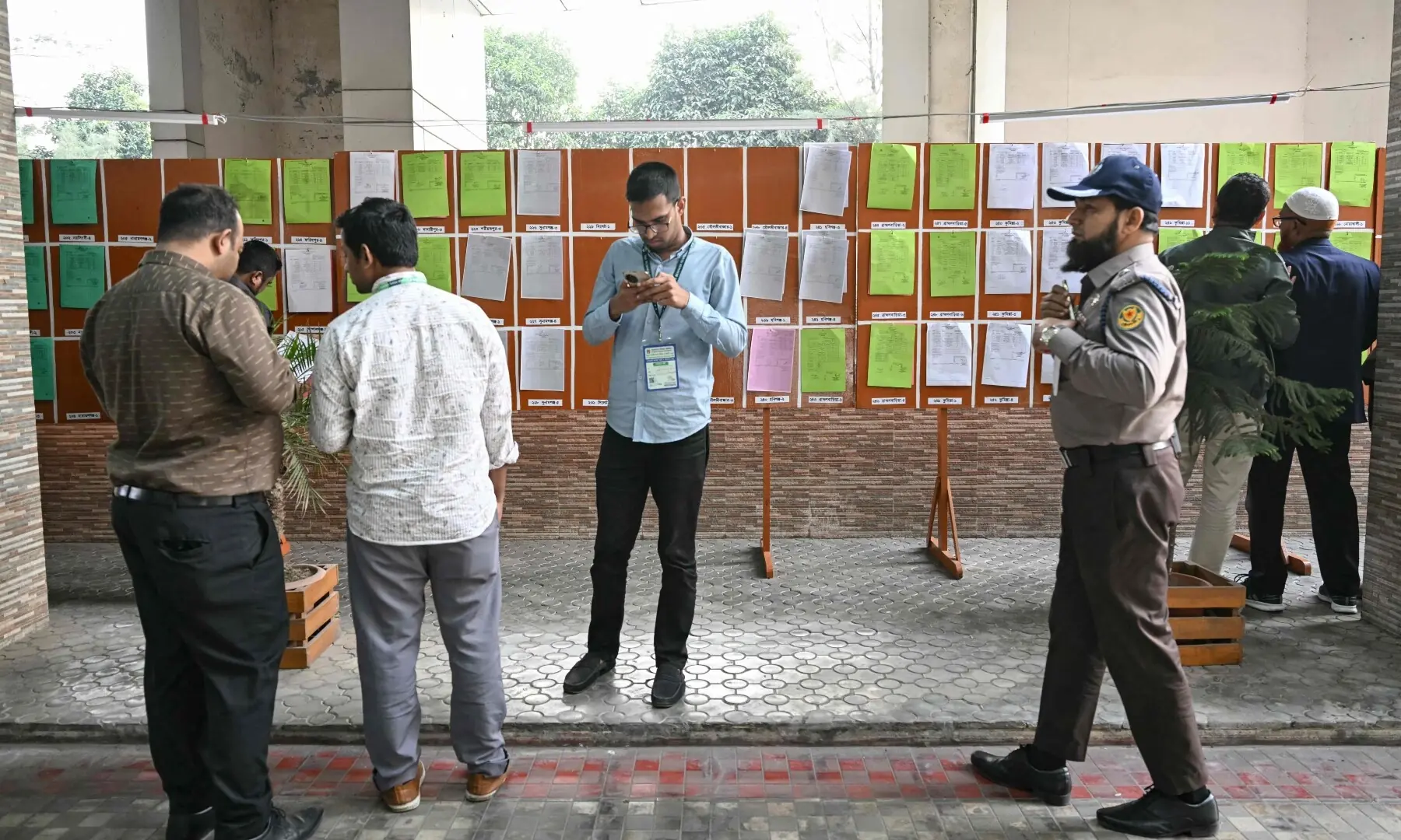 Members of the media look at documents of preliminary election results at the Election Commission office in Dhaka on February 13, 2026. &mdash;AFP