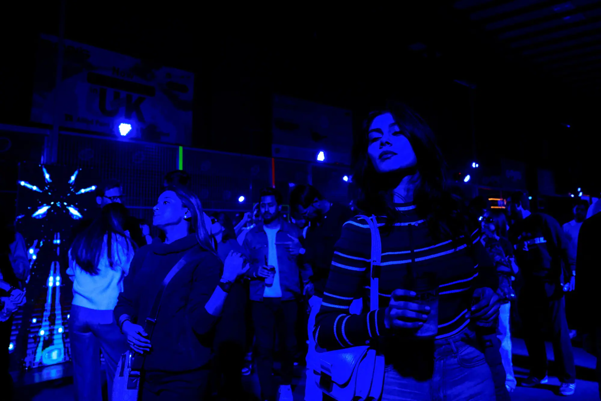 Participants dance to music amid a shower of neon light during a neon padel party organised by 12xperience, at the Padelverse . Photo: Reuters