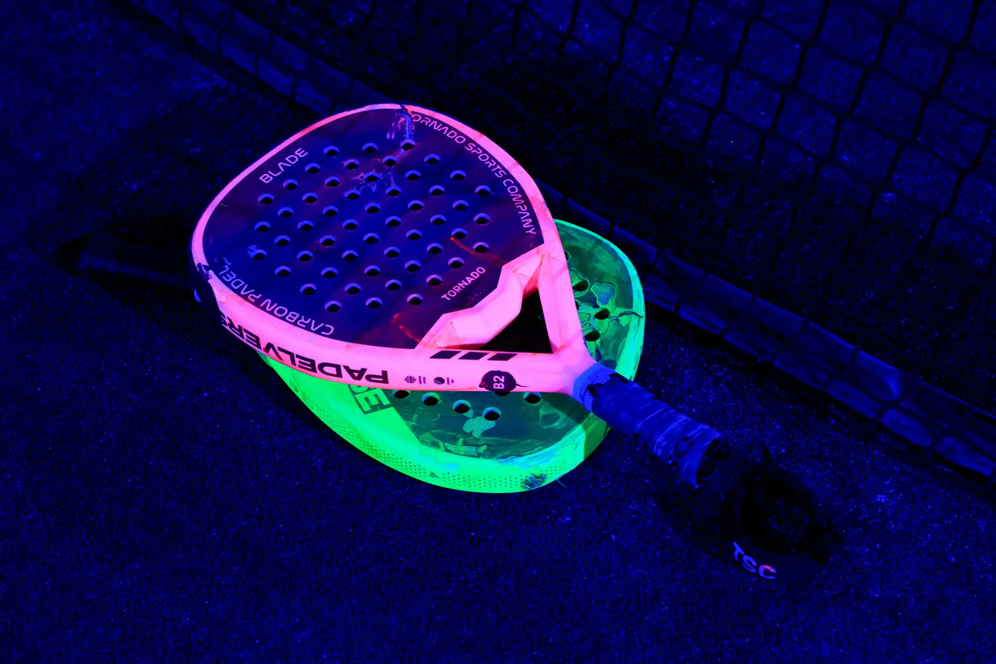 A pair of fluorescent padel rackets lie amid a shower of neon light during a neon padel party organised by 12xperience, at Padelverse. Photo: Reuters
