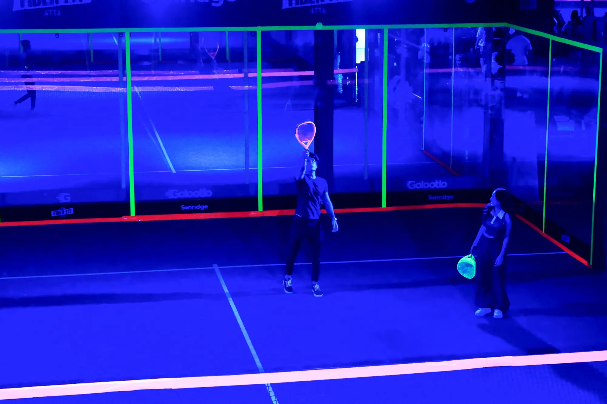 Participants play amid a shower of neon light during a neon padel party organised by 12xperience, at Padelverse. Photo: Reuters